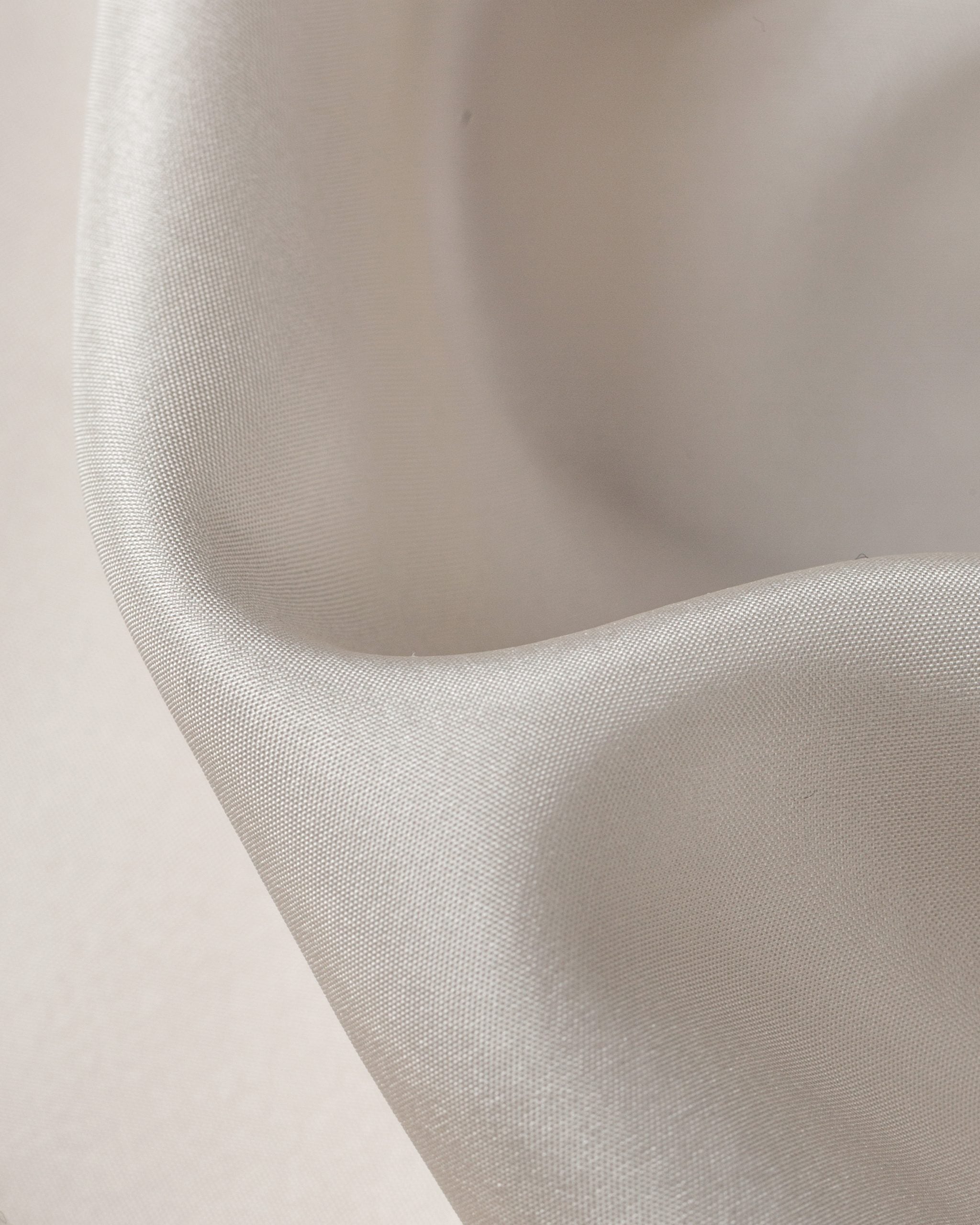 Close-up of habutai fabric texture on a light pink background
