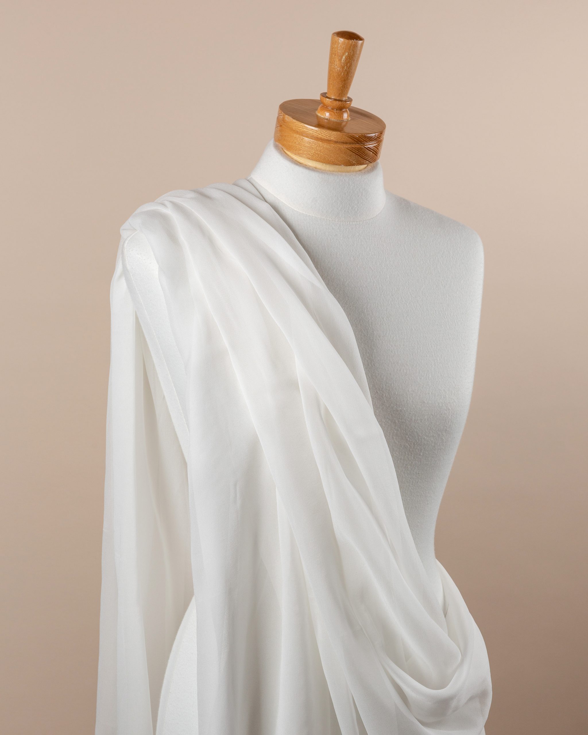 Undyed silk georgette fabric draped over a mannequin on a beige background