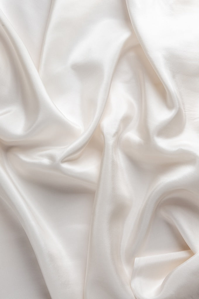 Close-up of crumpled, undyed white Habutai silk fabric with folds