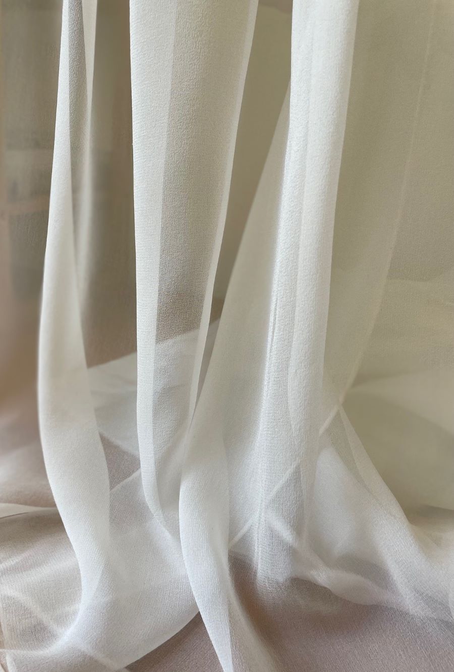 Close-up of sheer undyed silk georgette fabric with a soft focus background