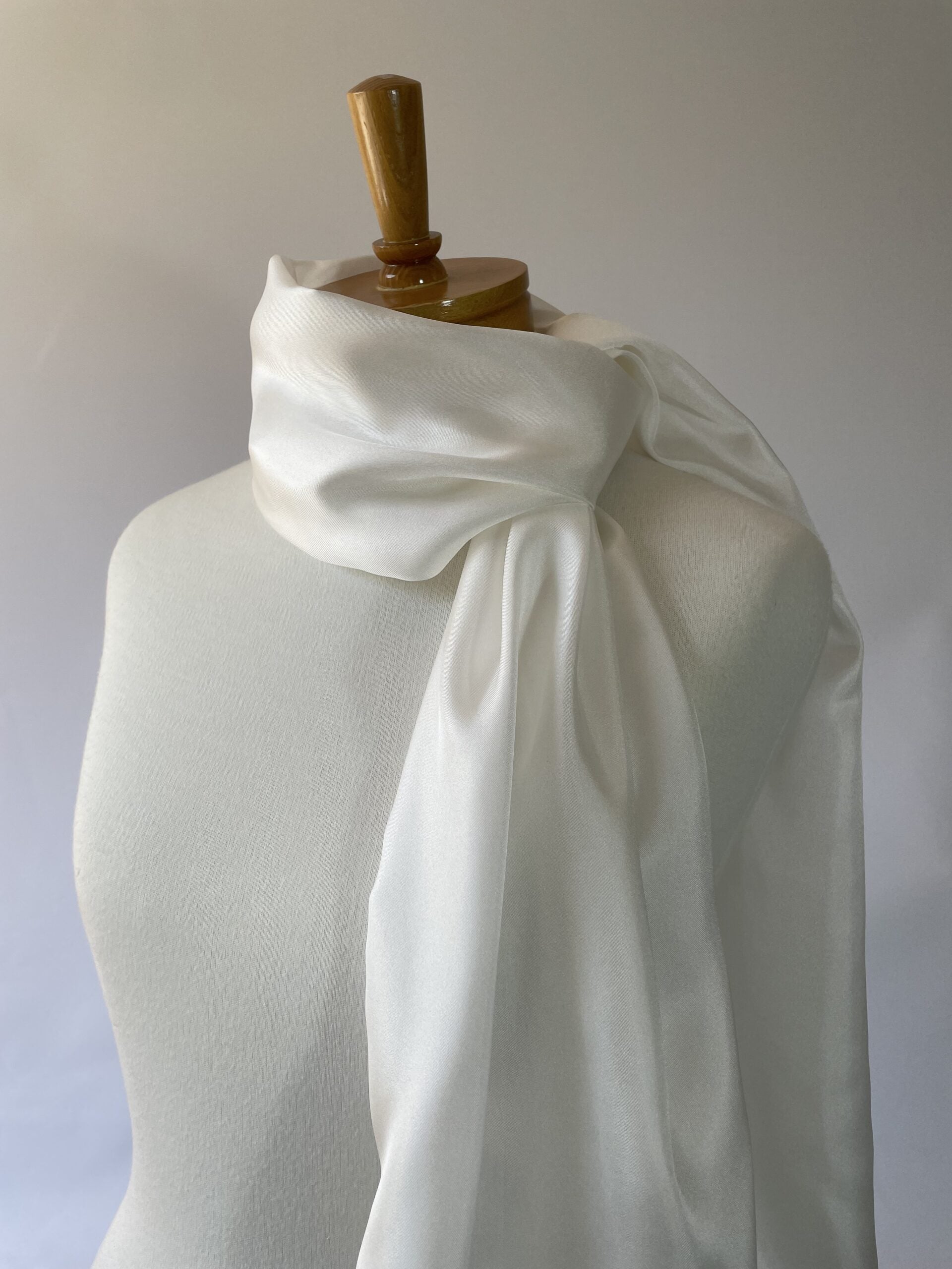 Undyed white silk twill scarf draped over a mannequin against a plain background