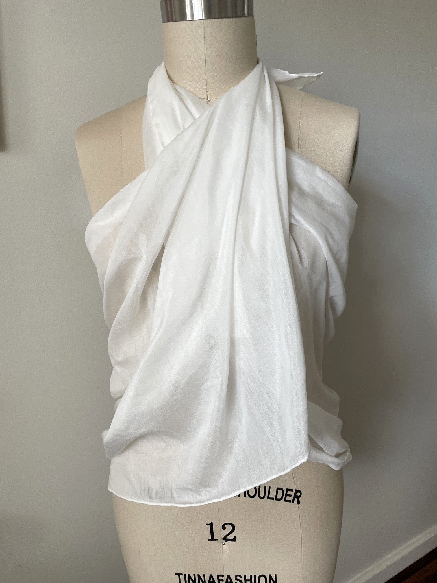 Undyed silk cotton voile sarong tied at the neck draped over a mannequin with on a plain background