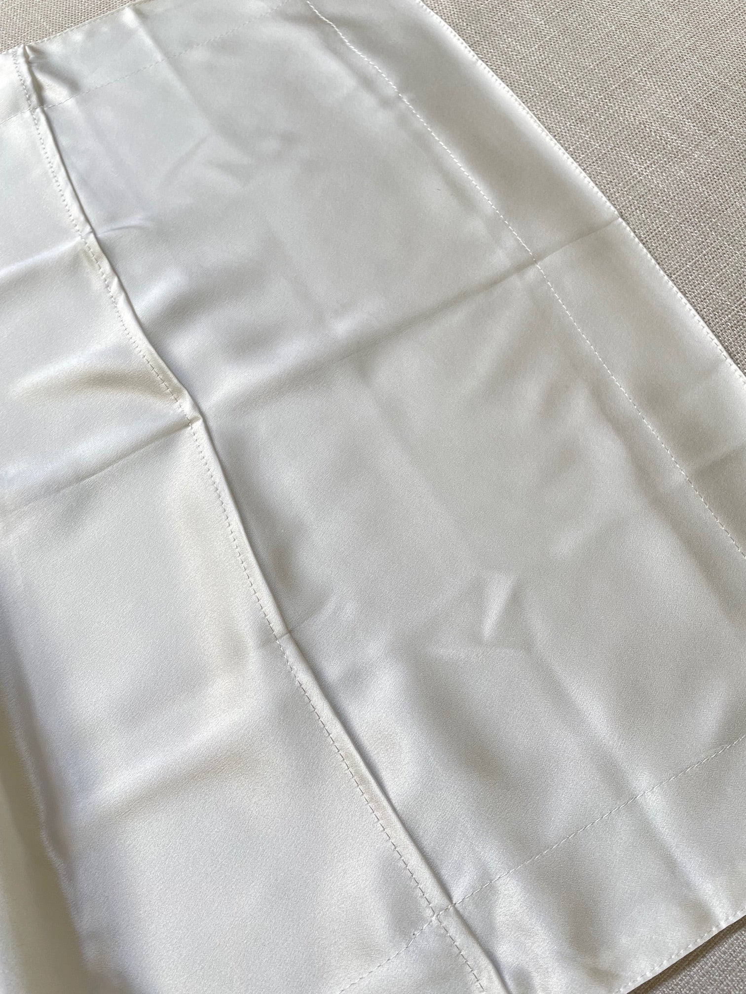 Close-up of a Undyed silk satin pillowcase back view.
