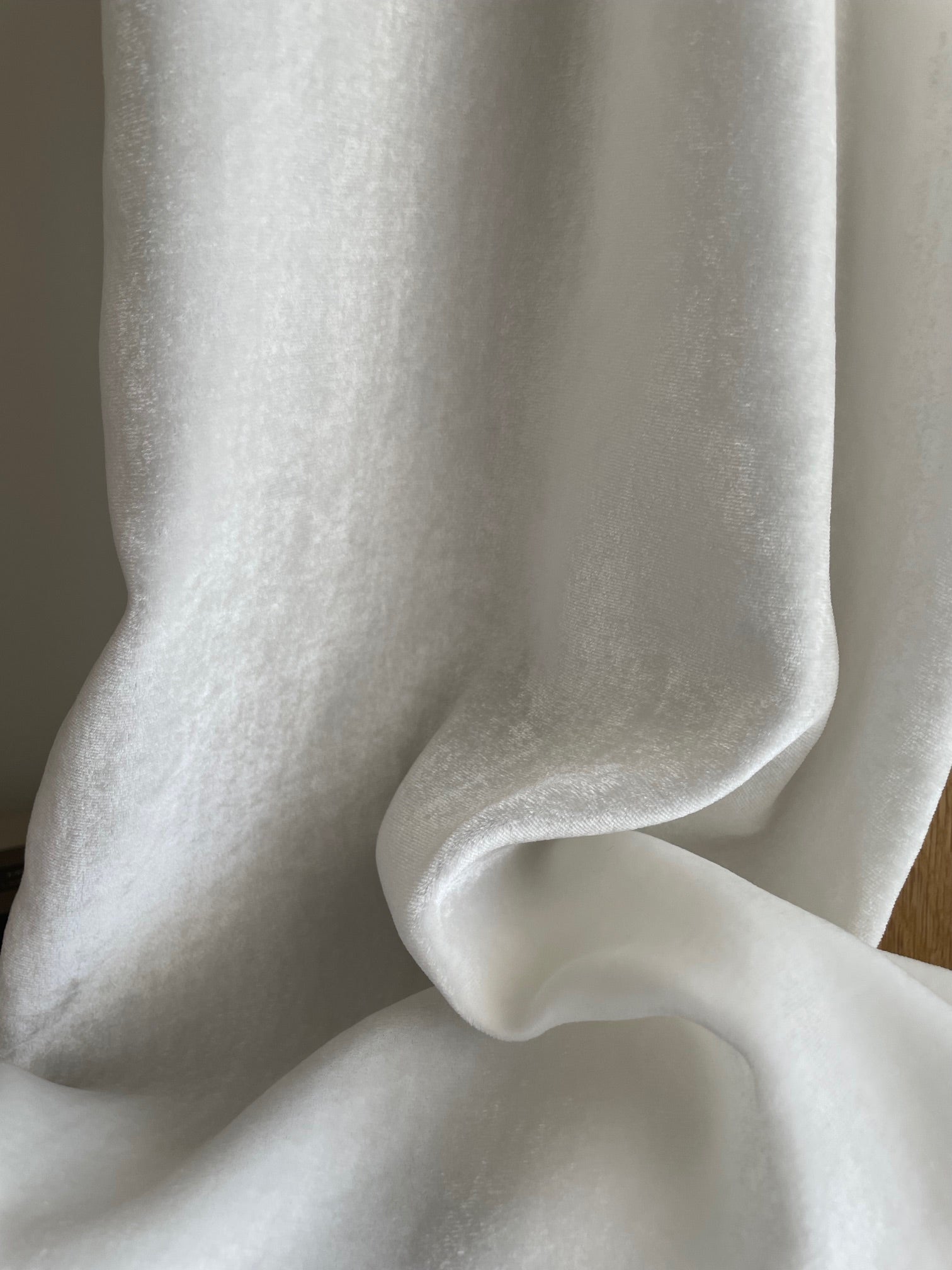 Close-up of white undyed silk viscose velvet scarf with folds on a neutral background