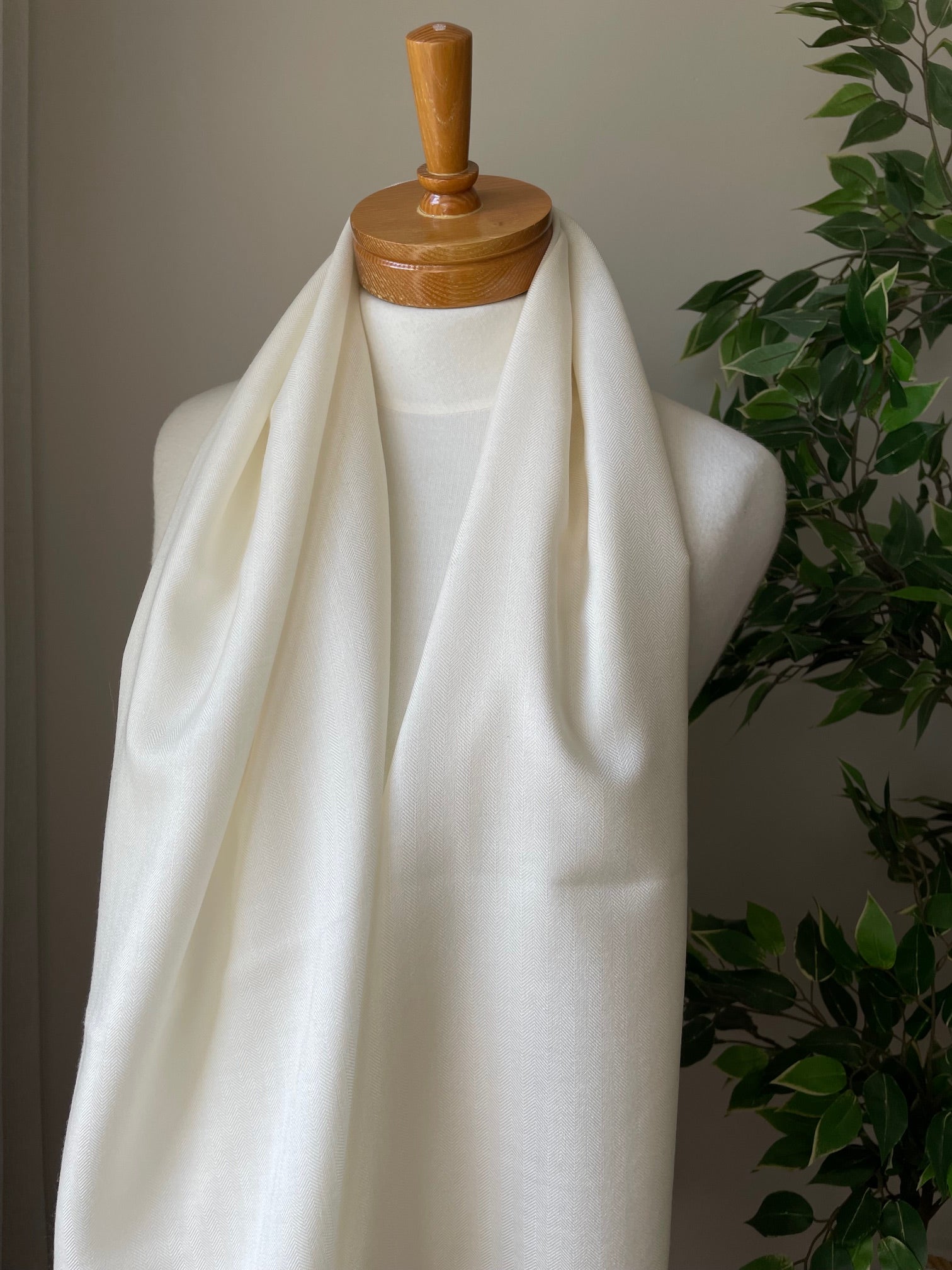 undyed silk wool scarf on a mannequin with green leaves in the background