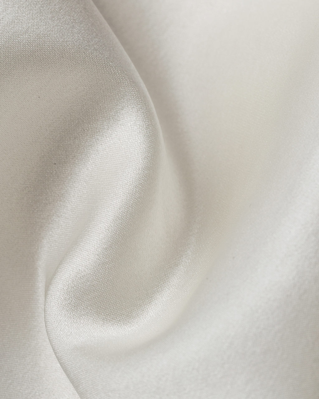 Close-up of undyed stretch satin silk fabric with a soft texture
