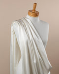 Undyed stretch satin silk fabric draped over a mannequin on a beige background