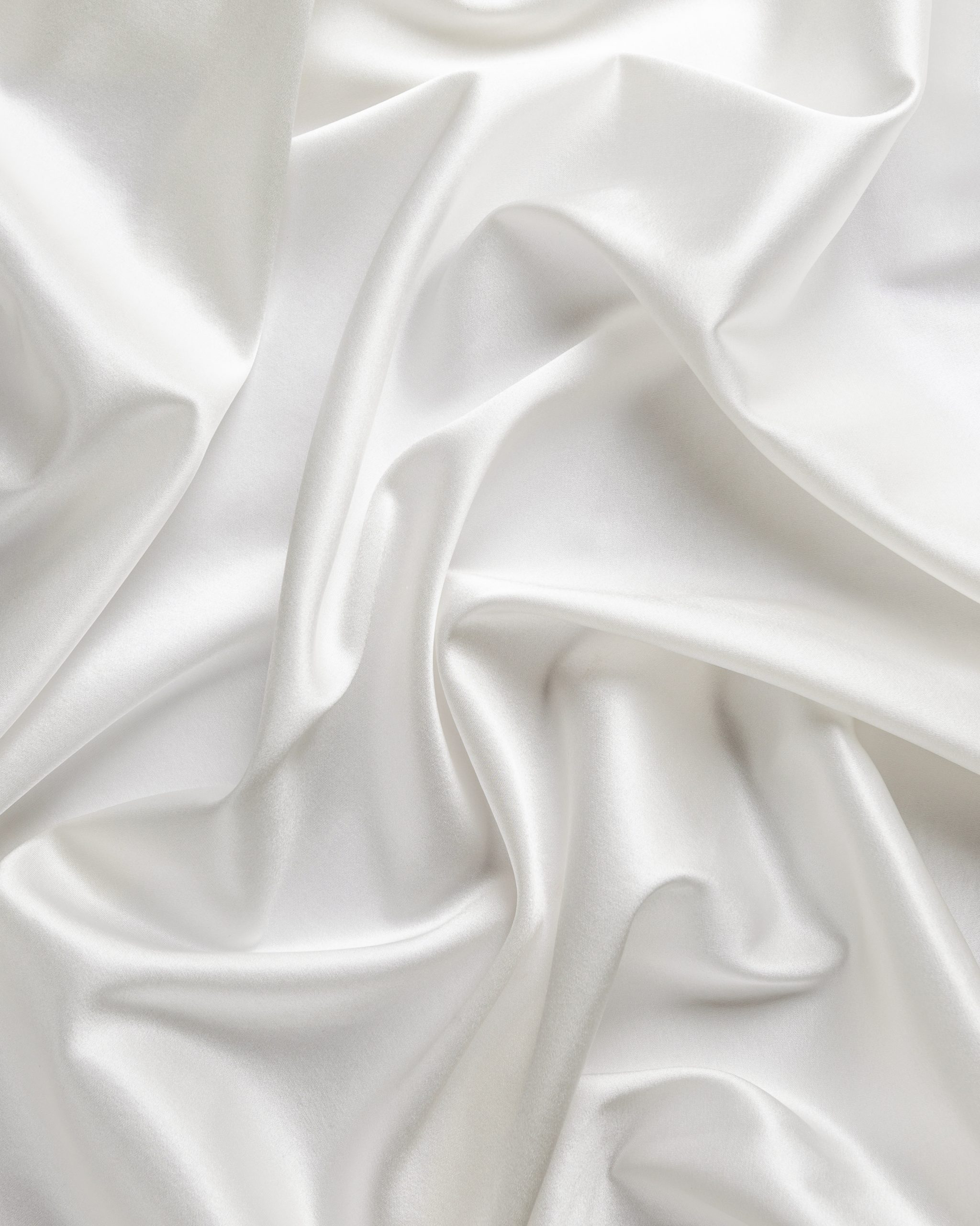 Close-up of undyed stretch satin silk fabric with folds 