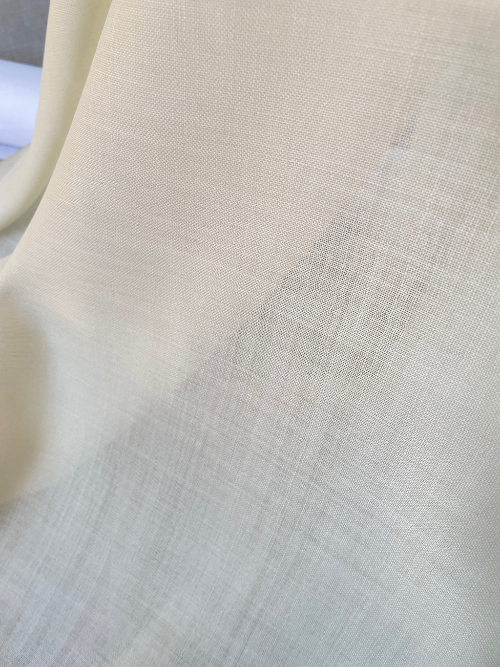 Close-up of undyed wool gauze fabric with a subtle pattern