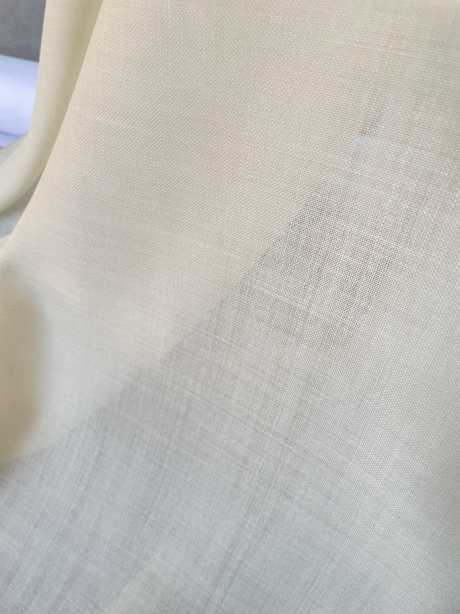 Close-up of undyed wool gauze fabric with a subtle pattern
