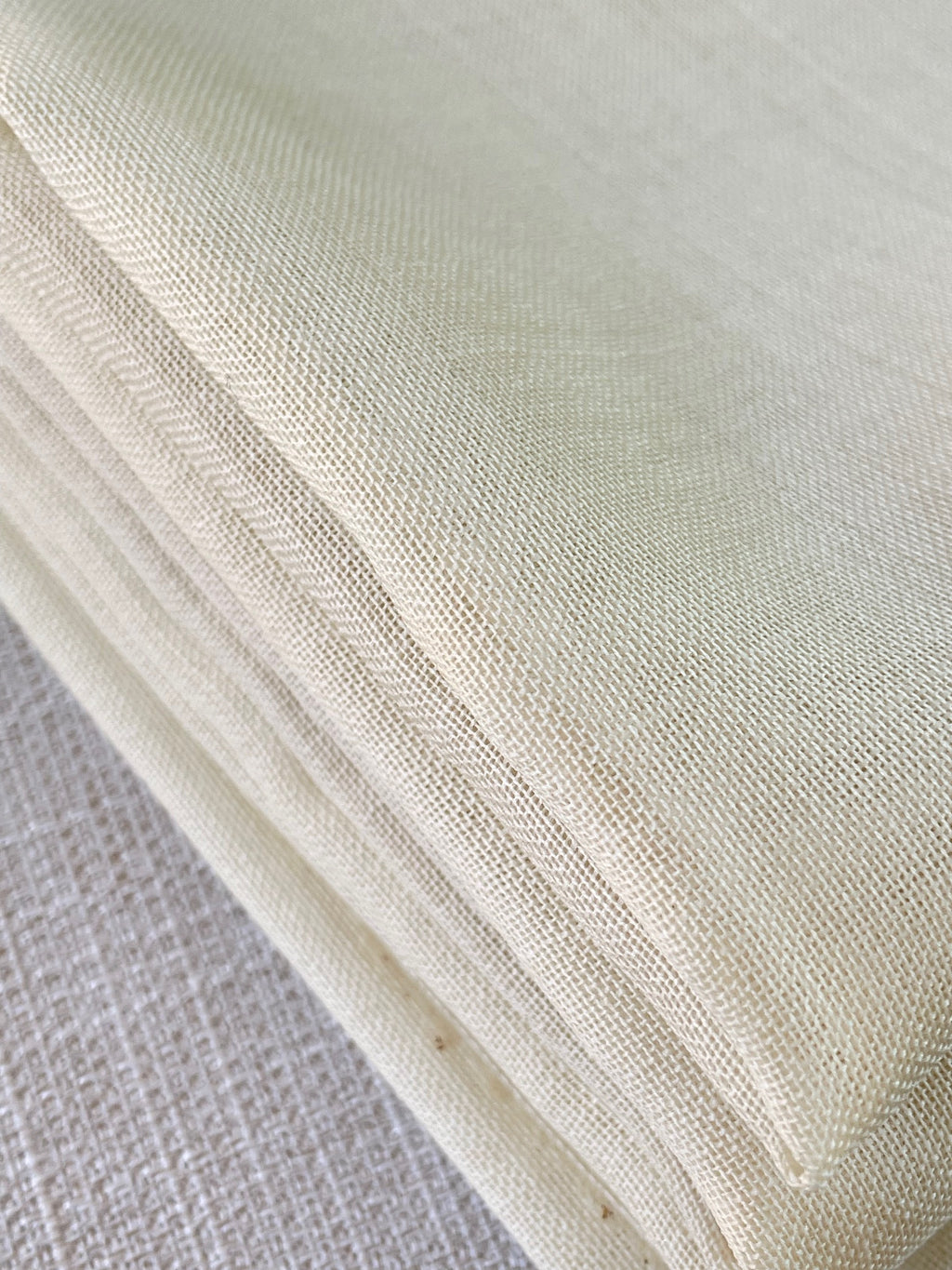 Close-up of undyed wool gauze fabric with a textured pattern