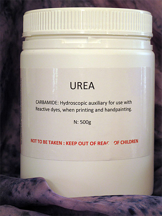 Container of urea powder with text on a purple background